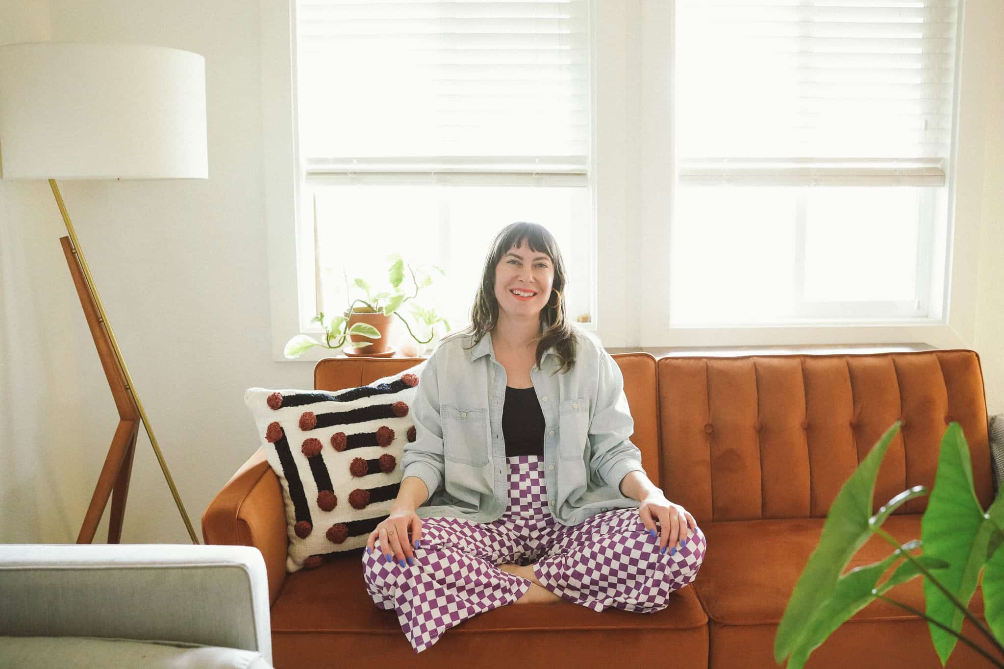 Fawn, a queer real estate agent in Denver is photographed by Queer Joy Photo on her couch in her home.