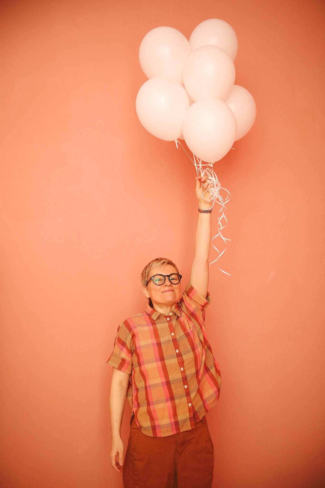 photographer at Denver's Queer Joy Photo holds balloons for a photo session