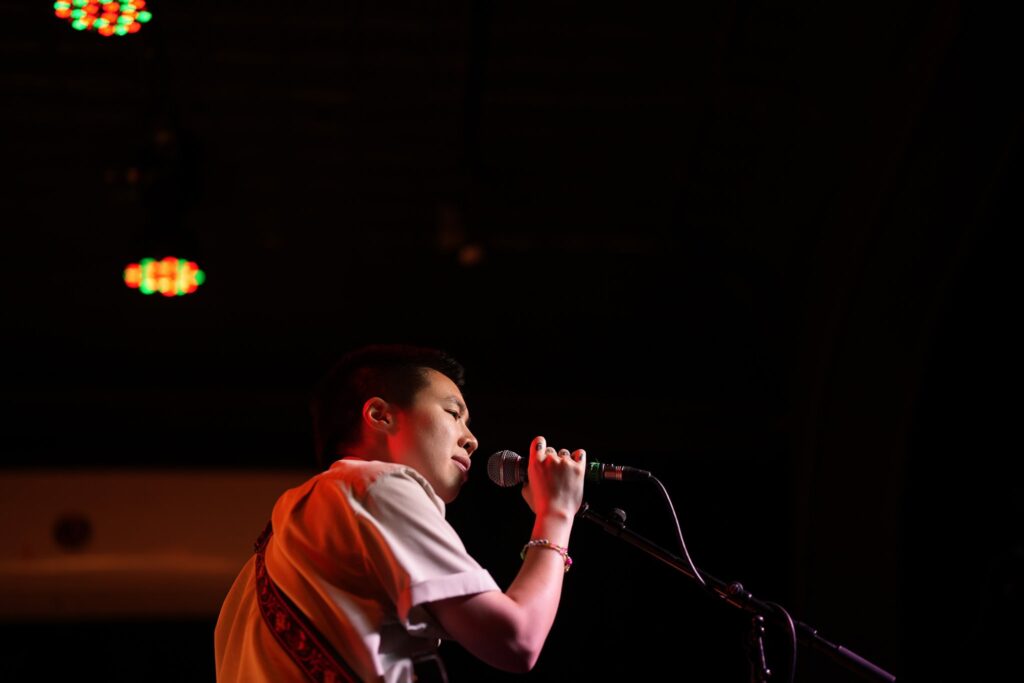 Photo of Ngoc singing at their recent show in Denver at Globe Hall. 